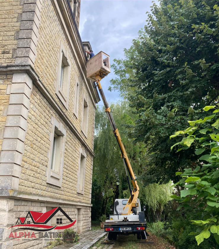 Camion nacelle Alpha Bâtiment déployé le long d'une façade en pierre