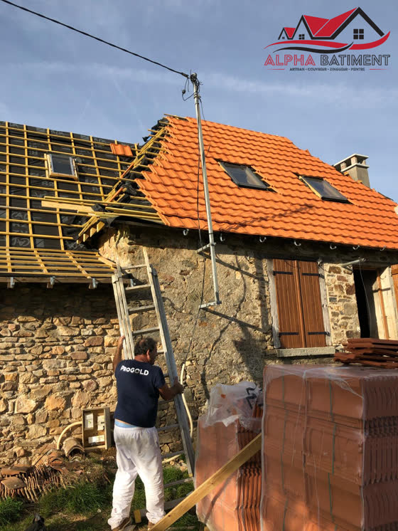 Pose de tuiles neuves sur une toiture en rénovation
